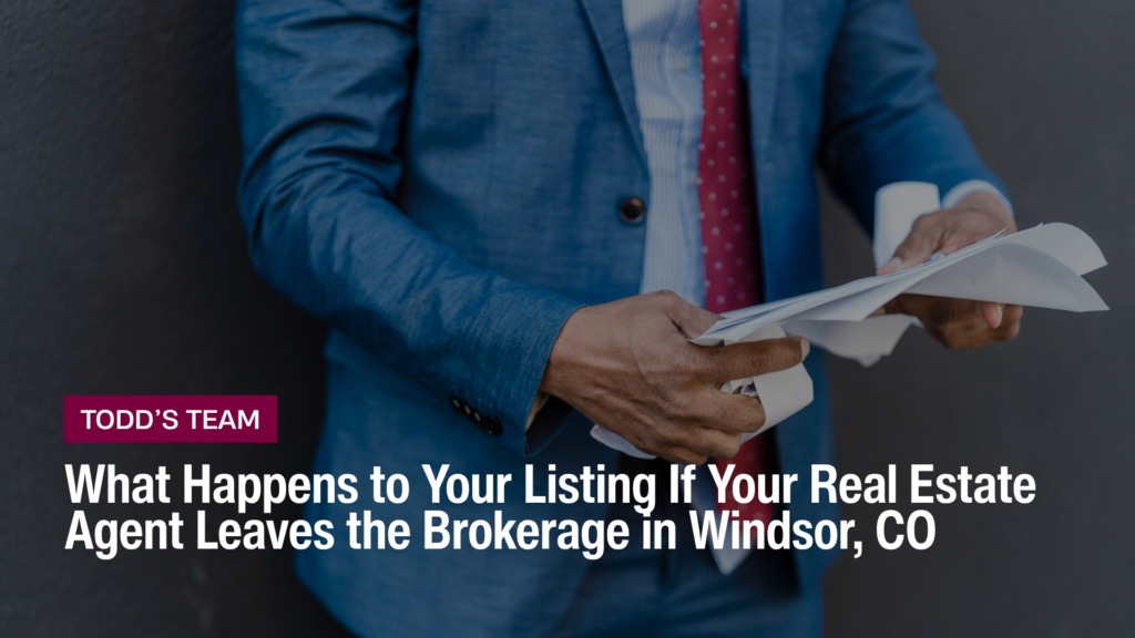 Real estate agent in a blue suit sorting listing paperwork, for Windsor CO sellers whose agent leaves the brokerage